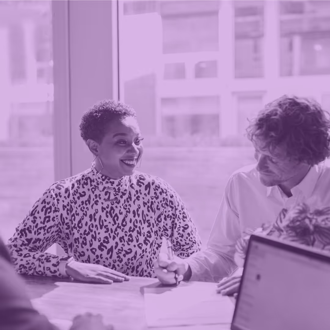 A man and woman customs professionals meeting at a table to discuss customs analytics.